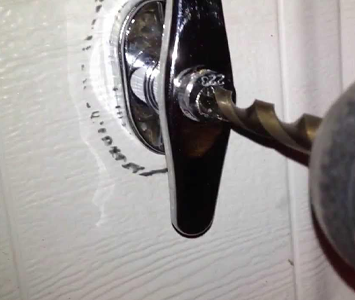 Locksmith drilling out an old garage door lock prior to fitting a new one